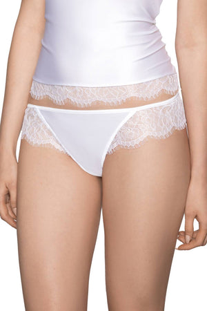 A person is wearing a white top and a matching Roza Erii White Thong by Roza, both decorated with delicate eyelash lace trim. The person's hands rest relaxed at their sides, and the image captures from waist to mid-thigh.