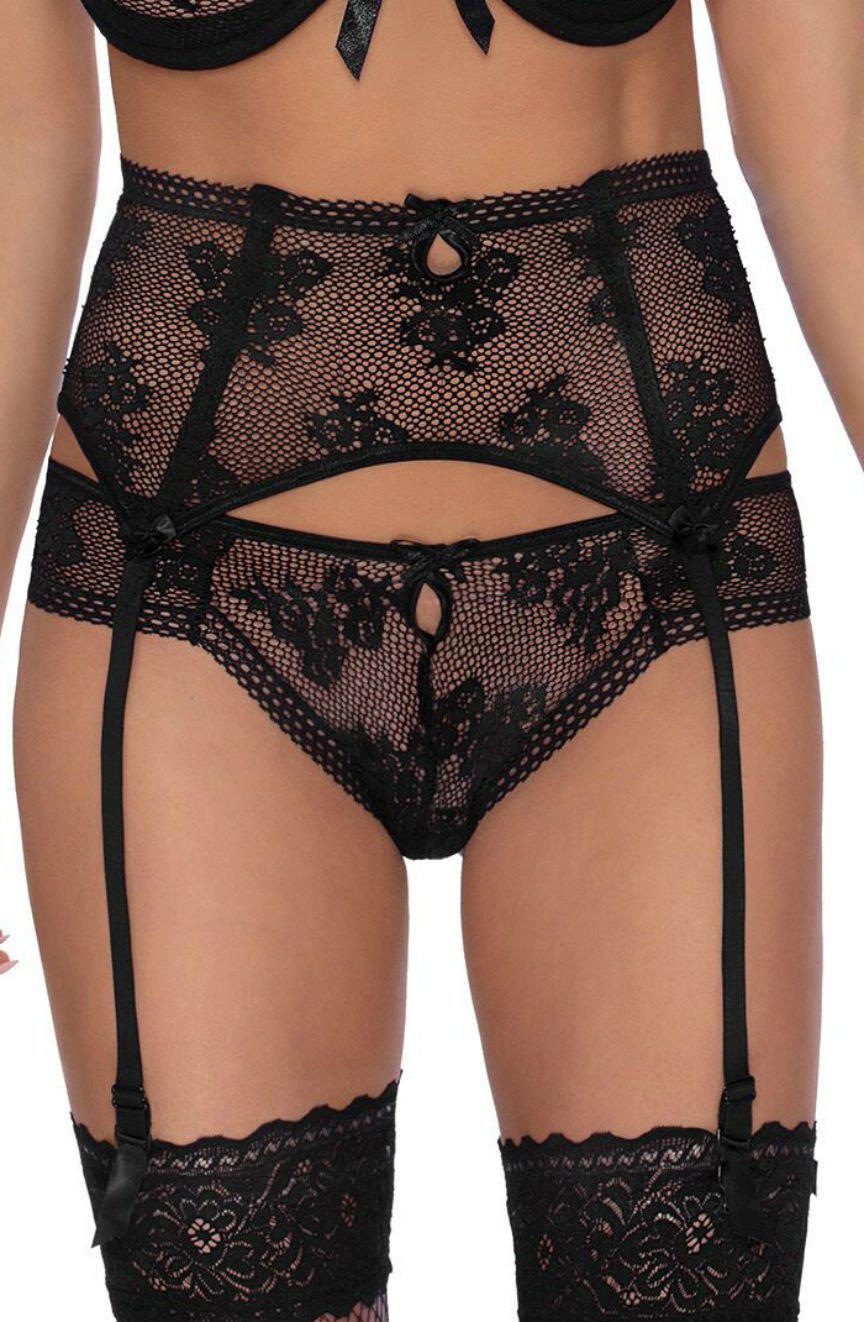 A person is modeling black lace lingerie in a sensual style, which includes a bra, suspender belt, Roza's Euterpe Black Thong, and thigh-high stockings. The lingerie features intricate floral patterns and small bows with cut-out details on the garter belt and thong.