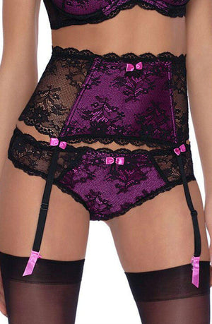 A close-up of a person wearing a matching set of purple and black lace lingerie, including a push-up bra, high-waisted Roza Fifi Suspender Belt Black, panties, and thigh-high stockings. The delicate lace design features intricate floral patterns, and small pink bows adorn the suspender belt and panties from the brand Roza.