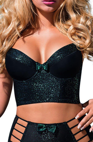 A blonde woman is wearing the Roza Ilaris Half-Corset in black from the brand Roza, featuring glitter detailing and a green bow in the center. She pairs it with matching high-waisted bottoms that have cut-out sides and a green bow on the waistband. The corset has an adjustable hook and eye fastener for a perfect fit. Her hair is styled in loose curls, and she is wearing pink lipstick.
