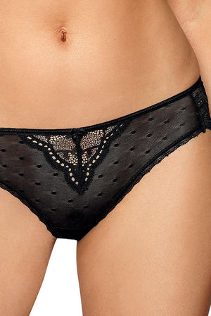 A person is wearing the Roza Lagerta Brief Black from the Roza brand, which is made of black, semi-sheer lace with a dotted pattern and intricate detailing at the front. This delicate piece, packaged in a Roza box and adorned with a small bow in the center, reveals part of the person's midsection and upper thighs.