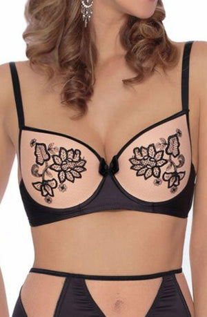 A person wearing the Roza Mehendi Push Up Bra in black and beige, which features floral embroidery with black straps and a small bow at the center. The matching high-waisted bottoms complete the set. Adorned with bridal mehendi, the person has curly hair and is wearing dangling earrings.