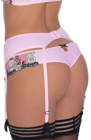 A person is shown from the back wearing a pink lingerie set with a matching Roza Natali Pink Suspender Belt and stockings from the Roza brand. The lingerie features floral lace detailing and small black bows, accentuating its delicate beauty.