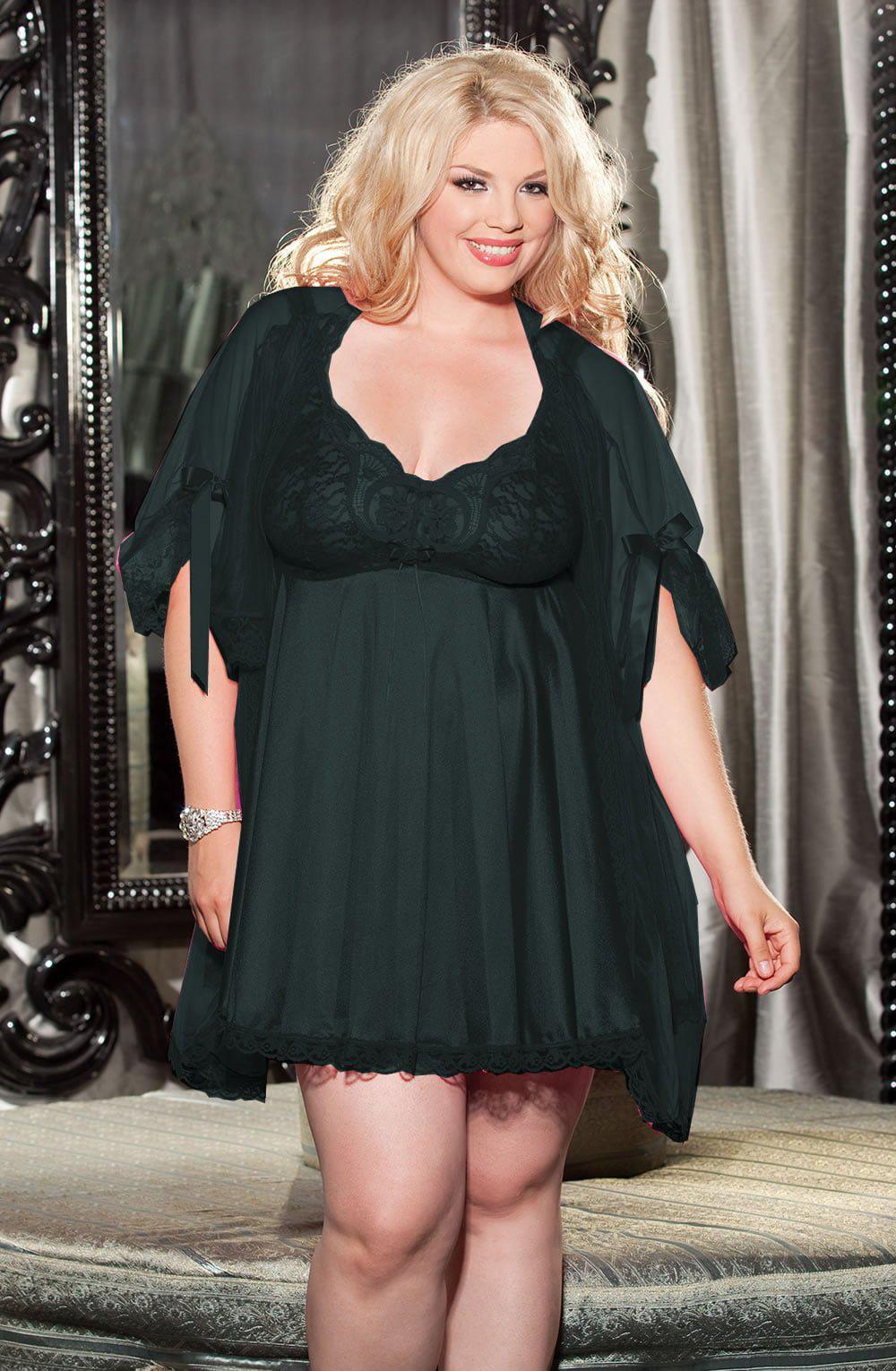 A smiling woman with blonde hair, wearing the Shirley Of Hollywood X3595 Black 3 Piece Babydoll by Shirley of Hollywood, stands in a room with ornate decor. She accessorizes with a silver watch on her left wrist.