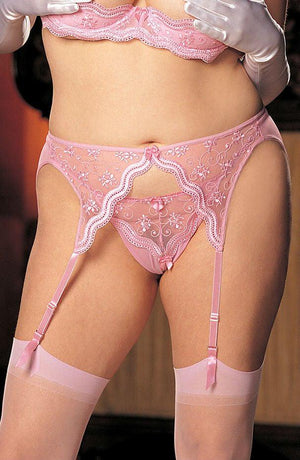 A person is wearing the Shirley Of Hollywood X622 Pink Garter Belt set, which includes beautifully scalloped embroidery, attached lace stockings, and matching pink panties from Shirley of Hollywood. The photo highlights their midsection and upper thighs. They are also accessorizing with white gloves.