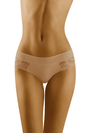 A close-up of a person's midsection wearing the Wolbar Cara Beige Brief luxury lace briefs by Wolbar, featuring intricate detailing on the sides. The skin tone appears tanned, with focus on the waist, hips, and upper thighs. The background is plain white.