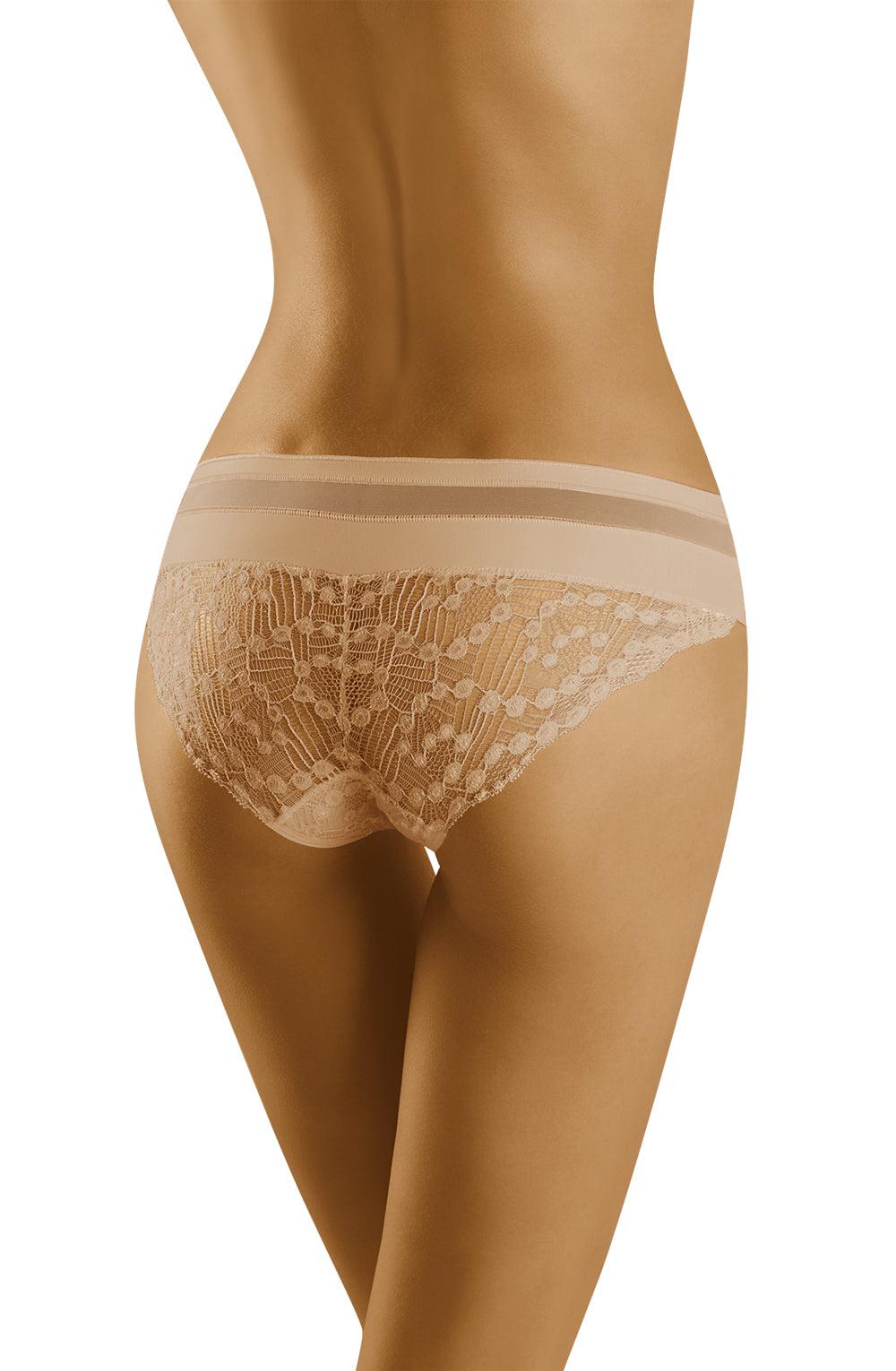 A woman is wearing beige Wolbar Leda Briefs featuring a wide elastic waistband. The image captures her from the back, showcasing the detailed lace embellishment and the fit of the underwear. The plain white background highlights the intricacies of these Wolbar briefs.