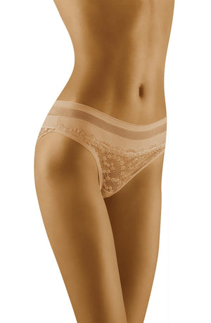 A person wearing the Wolbar Leda Beige Brief is shown from mid-torso to upper thighs. The brief features semi-sheer lace embellishments and a comfortable waistband, set against a plain white background.