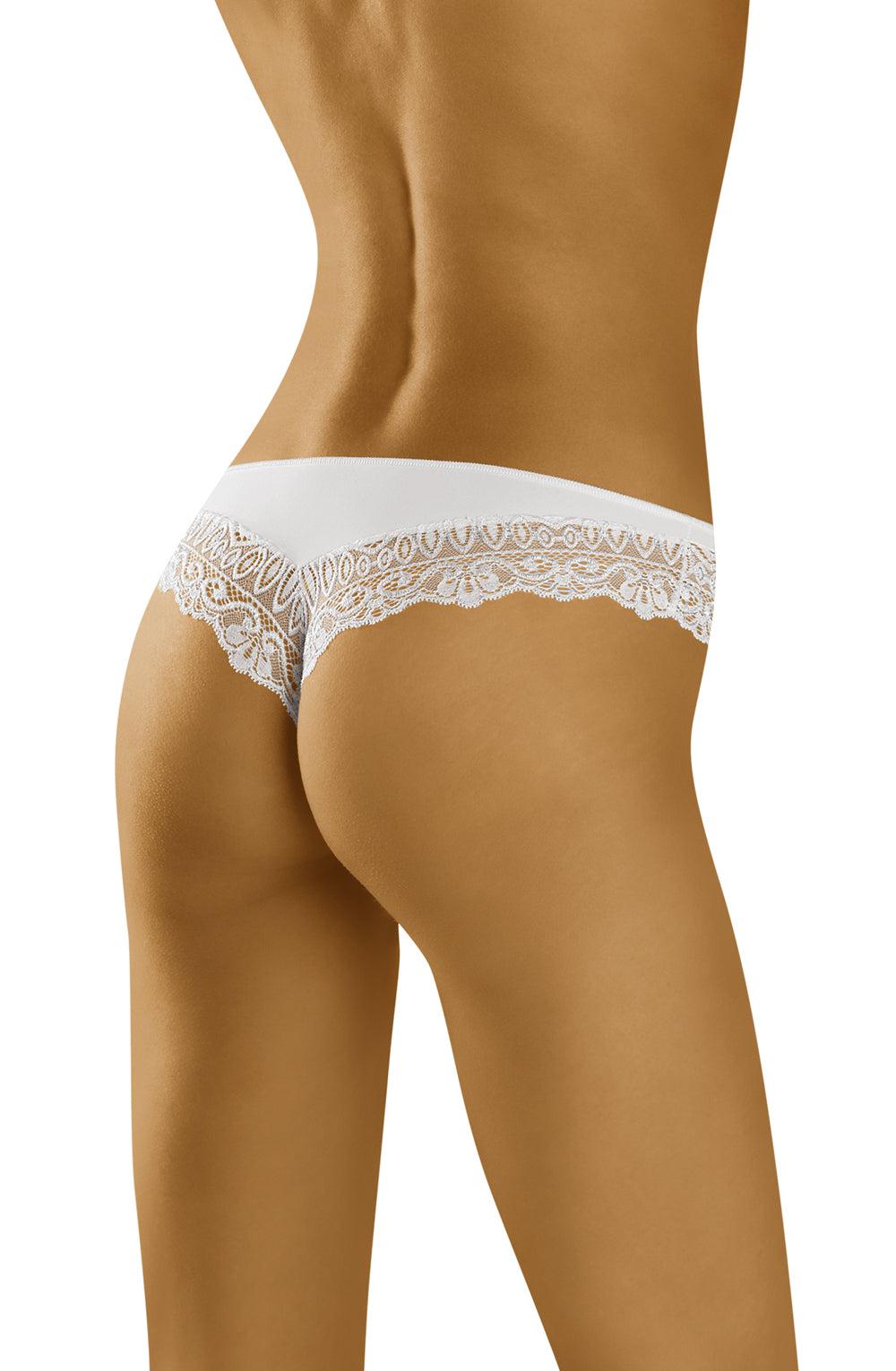 A person is seen from behind, wearing Wolbar Sirtaka White Thong lingerie. The image highlights the lower back and hips, showcasing the intricate lace design of the sexy thong. The skin tone is tan, and the setting appears neutral without any visible background elements.